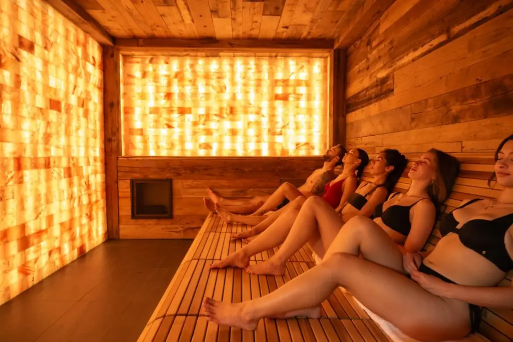 People relaxing in a warm salt lodge with illuminated salt walls.