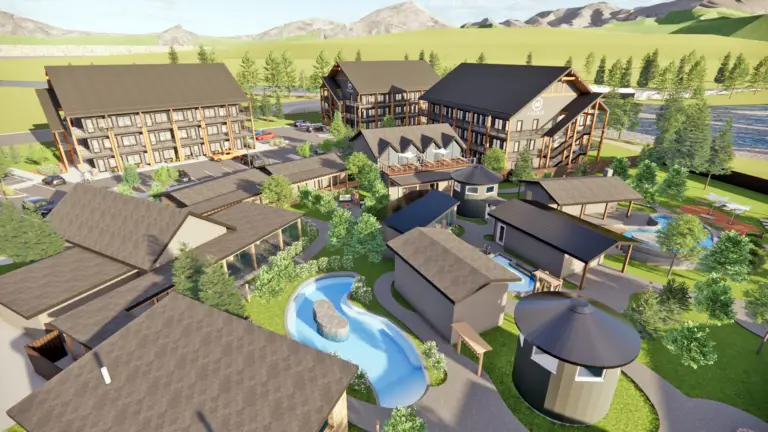 Aerial view of a modern resort complex with multiple buildings, pools, and landscaping.